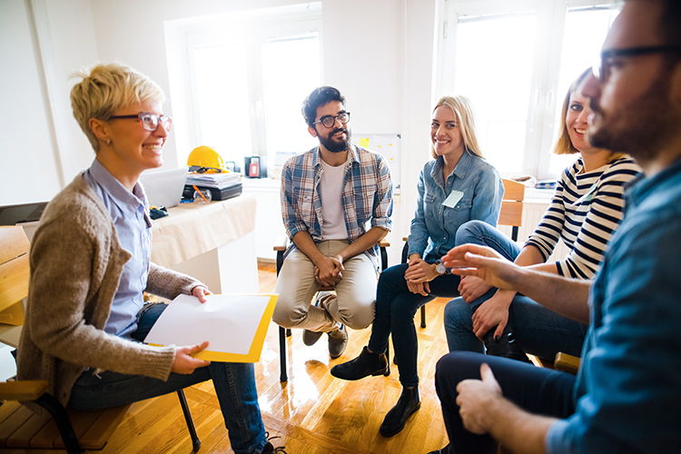 Group of people sitting in a circle on group therapy. Looking at